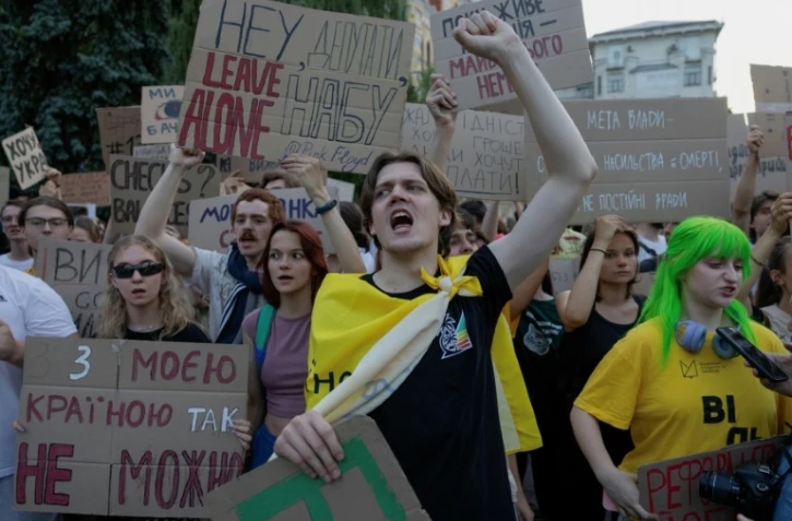 Des manifestants crient des slogans et brandissent des pancartes lors d'une manifestation contre une loi qui supprime l'indépendance des agences de lutte contre la corruption NABU et SAPO, à Kiev, le 24 juillet 2025