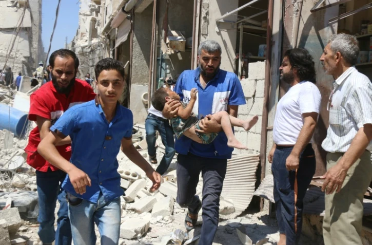Un enfant blessé évacué après un raid aérien le 23 juillet 2016 à Alep en Syrie