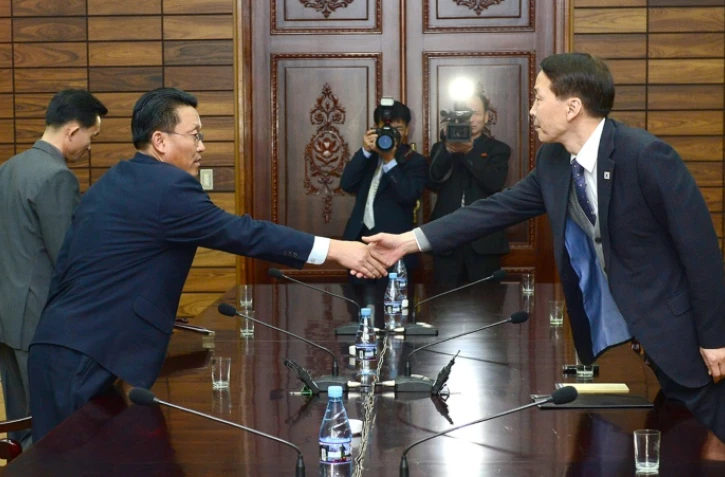 Kim Ki-Woong (d), haut responsable du ministère sud-coréen de l'Unification serre la main de son homologue nord-coréen, lors d'une rencontre à Panmunjom, le 26 novembre 2015 dans la zone démilitarisée entre les deux Corées
