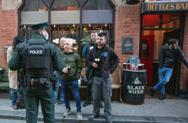 Un policier s'entretient avec les clients d'un bar à Belfast, en Irlande du Nord, le 16 octobre 2020