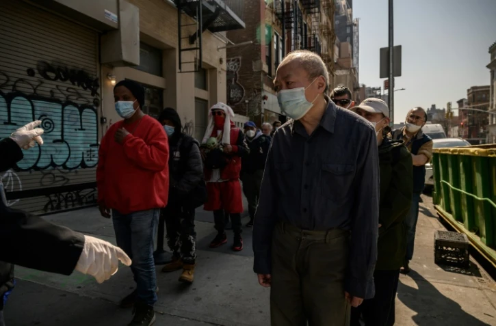 Des personnes font la queue pour une distribution de repas gratuits à New York le 16 mars 2022