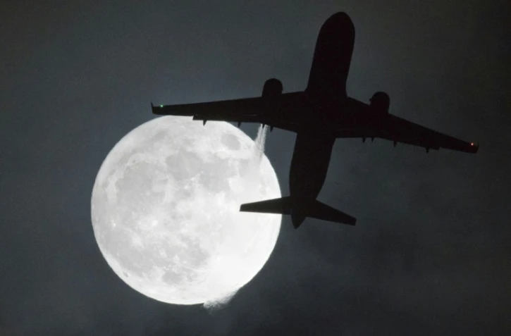 Un avion passe devant une "super lune", le 1er janvier 2018 à Londres