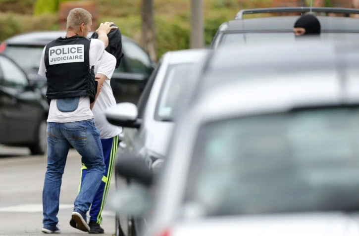 Un policier arrête un homme après une perquisition à Saint-Etienne-du-Rouvray, le 26 juillet 2016