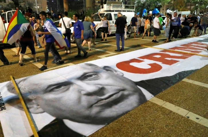 Une banderole avec une photo du Premier ministre Benjamin Netanyahu accompagnée de l'inscription "Crime Minister" est déroulée à Tel-Aviv, où la communauté druze a massivement manifesté le 4 août 2018 pour dénoncer une loi controversée