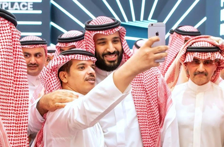 Le prince héritier d'Arabie saoudite Mohammed ben Salmane pose pour une photo avec un participant du forum Future Investment Initiative (FII) à Ryad, le 23 octobre 2018.