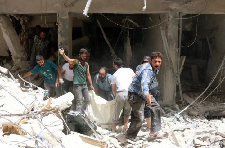 Le corps d'une victime extraite des décombres après un bombardement des forces syriennes le 3 juin 2016 à Alep