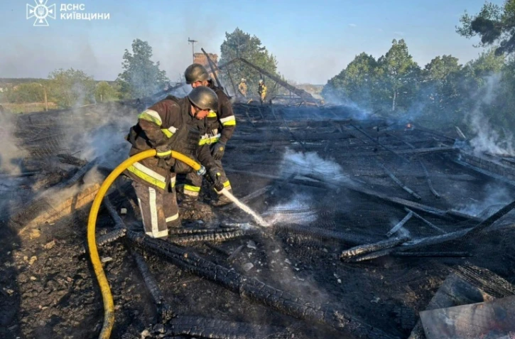 Image fournie par les services d'urgence ukrainiens de pompiers ukrainiens qui éteignent un incendie après une frappe de drone russe à Kiev le 12 mai 2026