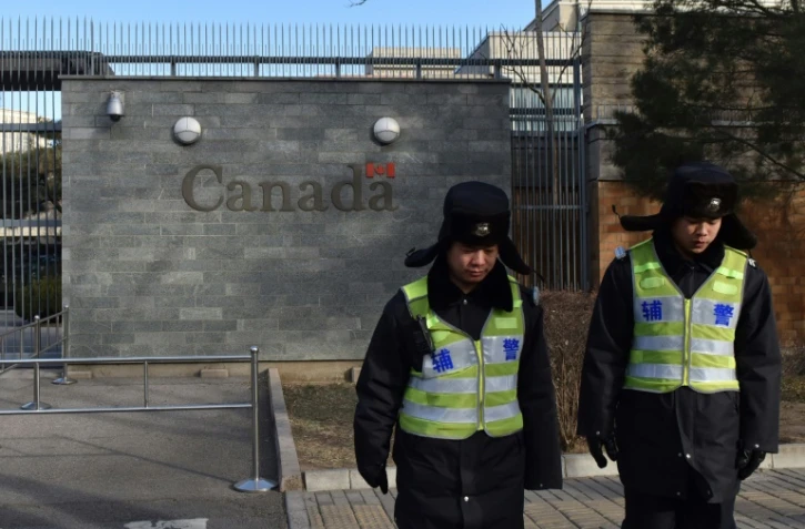 Des policiers chinois devant l'ambassade du Canada à Pékin le 15 janvier 2019

