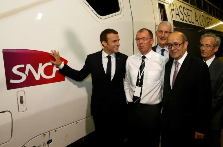Le président de la République Emmanuel Macron (g),   accompagné notamment du patron de la SNCF Guillaume Pepy (c., arrière-plan) et du ministre des Affaires étrangères Jean-Yves Le Drian (2e à d.) le 1er juillet 2017 à la gare Montparnasse à Paris