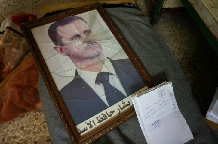 Un portrait de Bachar al-Assad au cadre brisé dans un bâtiment de la Direction de la sécurité politique du régime syrien à la périphérie de la ville de Hama (centre), le 7 décembre 2024