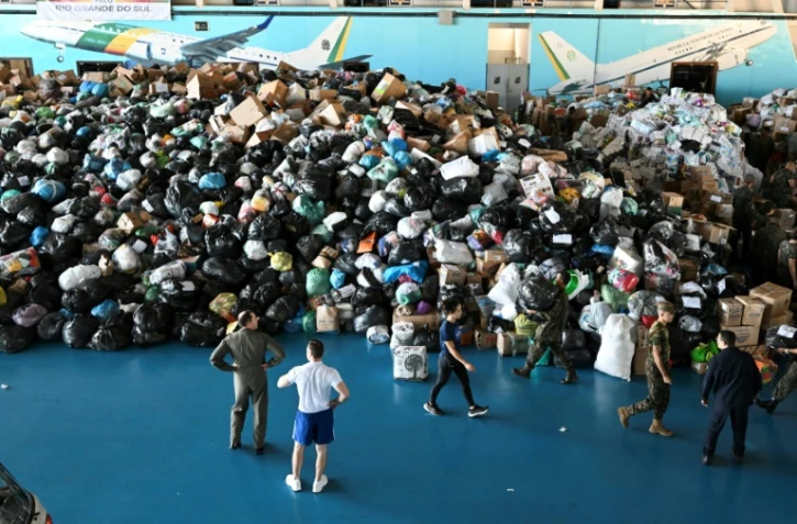 Des soldats de l'armée de l'Air brésilienne préparent des dons à envoyer aux victimes des inondations dans l'Etat du Rio Grande do Sul sur la base aérienne de Brasilia, au Brésil, le 10 mai 2024
