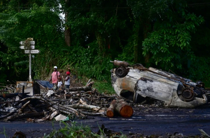 Des épaves de voitures incendiées à Fort-de-France, en Martinique, dans les Caraïbes, le 13 octobre 2024, après des émeutes liées à la vie chère