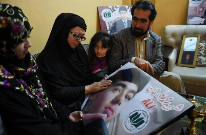 La famille d'un élève de l'Ecole publique de l'armée (APS) avec la photo de leur fils le 11 décembre 2015 à Peshawar