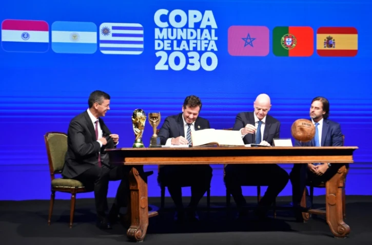 Le président de la Conmebol Alejandro Dominguez (2e g) et le président de la FIFA Gianni Infantino (2e d), entourés du président du Paraguay Santiago Peña (g) et du président de l'Uruguay Luis Lacalle (d), signent le procès-verbal de la Coupe du monde 2030 lors du 78e Congrès ordinaire de la Conmebol à Luque, le 11 avril 2024 au Paraguay