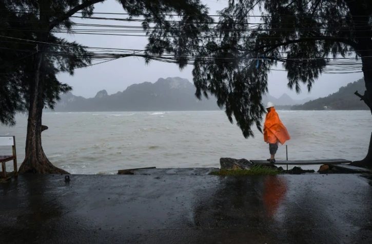 Un homme monte la garde, le 4 janvier 2019, sur un quai vide dans la région de Surat Thani, dans le sud de la Thaïlande, où tous les transports sont immobilisés avant l'arrivée de la tempête tropicale Pabuk