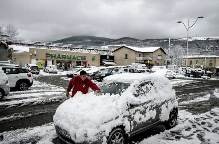 Un homme déneige sa voiture à Saint-Etienne, après les chutes de neige du 1er avril 2022