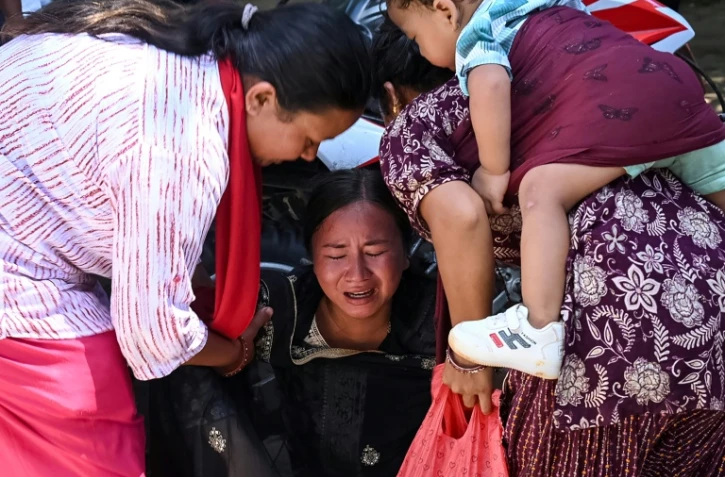 Une femme s’effondre tandis qu’elle attend l’arrivée de ses proches dans un camp militaire après avoir été secourue des zones touchées par des crues subites, dans la ville de Battar Bazar, dans le district de Nuwakot au Népal, le 27 août 2026