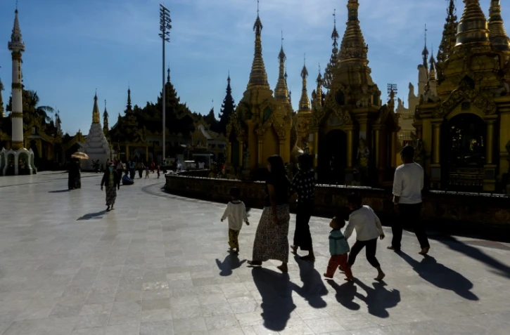 Des fidèles bouddhistes entrent dans le temple bouddhiste Shwedagon de Rangoun le 27 janvier 2022 
