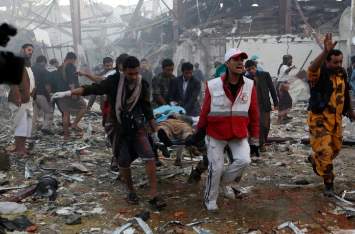 Des secouristes yéménites transportent un corps après des frappes attribuées à la coalition arabe à Sanaa, le 8 octobre 2016