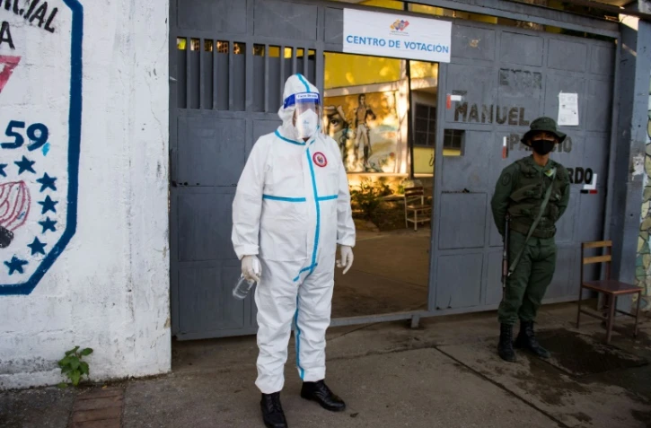 Un soldat vénézuélien portant une combinaison de protection attend les électeurs à un bureau de vote de Caracas, le 6 décembre 2020