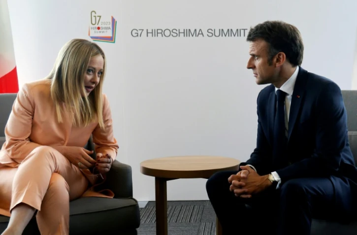 La Première ministre italienne Giorgia Meloni (gauche) s'entretient avec le président français Emmanuel Macron (droite) à Hiroshima (Japon) le 20 mai 2023