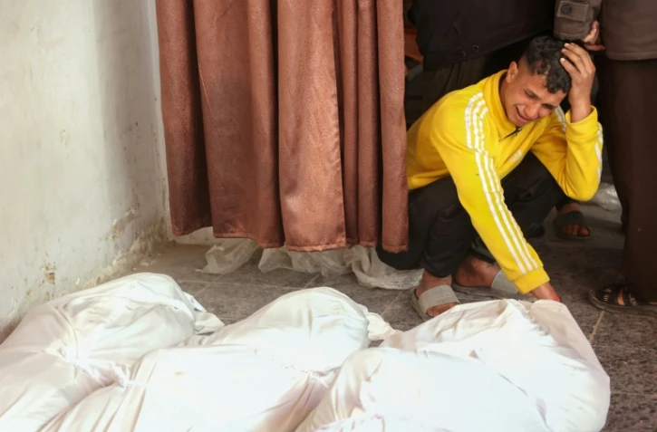 Un Palestinien se recueille devant les corps de ses proches tués dans une frappe aérienne israélienne dans le sud de la ville de Gaza, le 11 mars 2025
