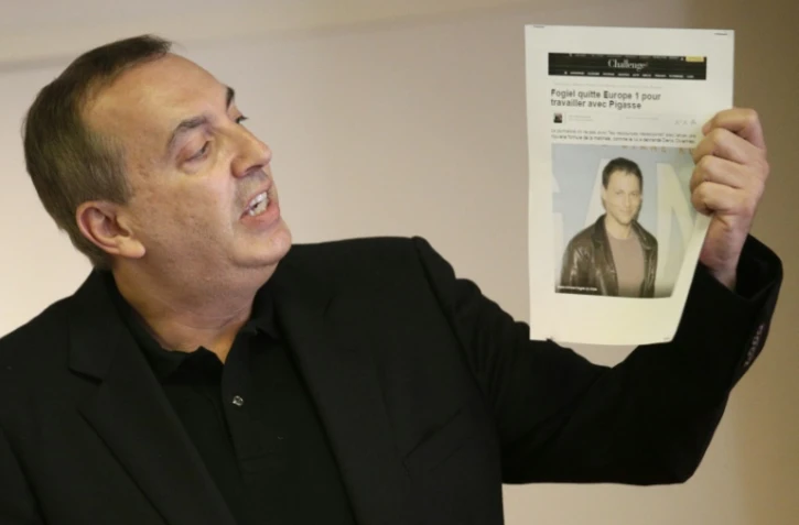 Jean-Marc Morandini montre une photo de Marc-Oliver Fogiel, Ă Paris le 19 juillet 2016