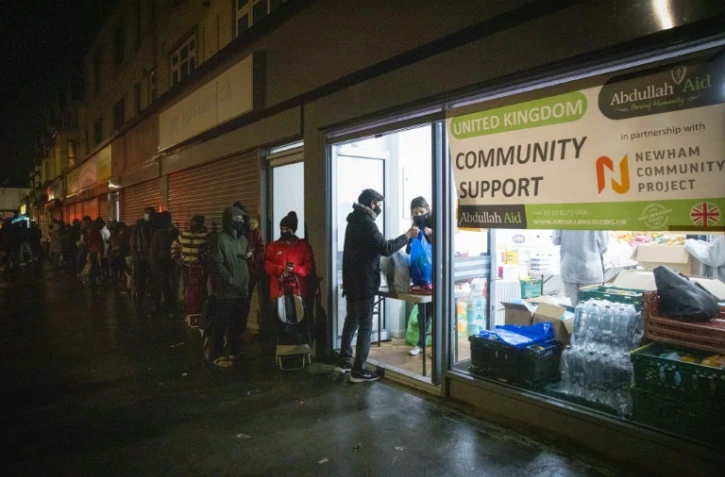 Des étudiants étrangers font la queue pour des distributions de colis d'aide alimentaire par l'association Newham Community Project à Londres le 16 février 2021