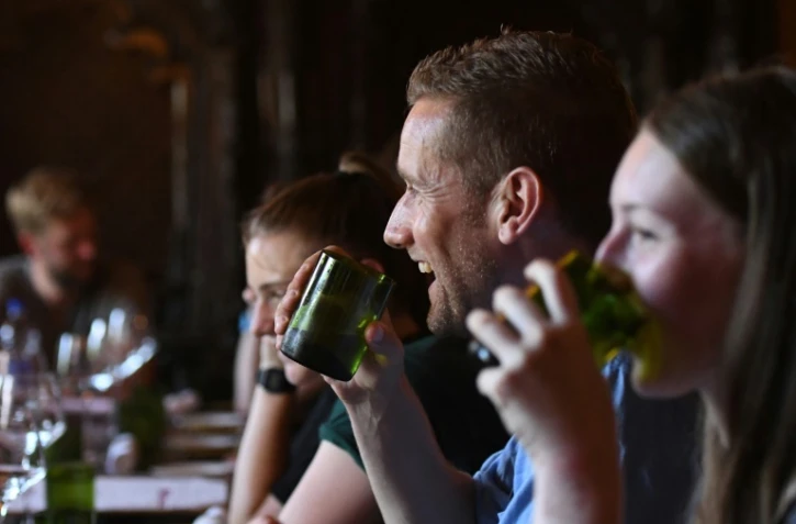 Les clients d'un restaurant de Katmandou boivent dans des verres fabriqués avec des bouteilles ramassées sur les pentes de l'Everest, le 1er août 2019