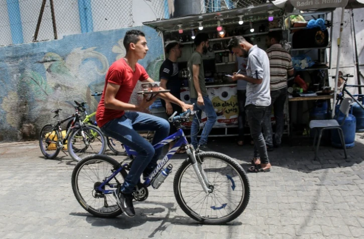 Un jeune homme livre des cafés à vélo près du marché de Rafah, dans la bande de Gaza, le 13 juillet 2020