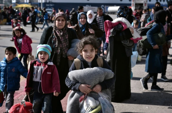 Des réfugiés syriens et irakiens embarquent sur des bus le 23 février 2016 depuis le port du Pirée à Athènes vers la frontière gréco-macédonienne