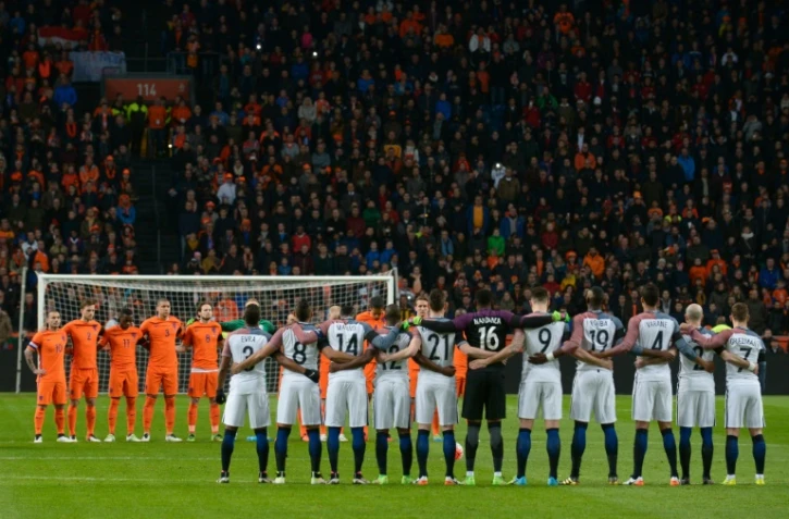Les joueurs des Pays-Bas et de la France observent une minute de silence au début de leur match amical à Amsterdam, le 25 mars 2016