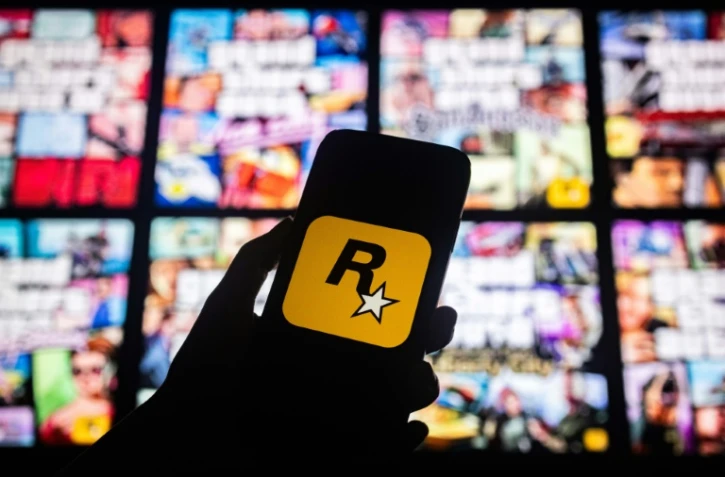 Le logo de Rockstar Games devant des pochettes de jeux vidéo de la franchise "Grand Theft Auto", dit GTA