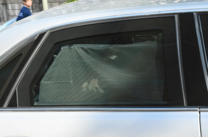 Mehdi Nemmouche caché par un rideau à bord d'une voiture de police le 12 septembre 2014 à Brxelles 