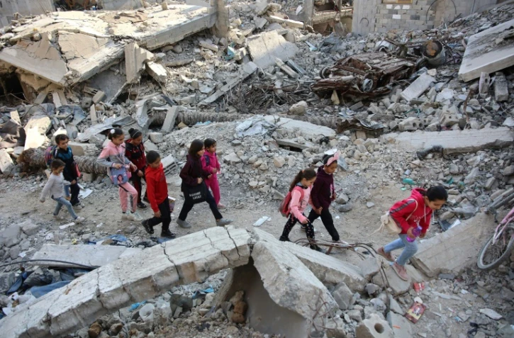 Des jeunes Palestiniennes marchent sur des décombres d'un bâtiment détruit lors d'un bombardement dans la ville de Gaza, le 9 novembre 2024