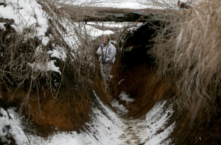 Un soldat ukrainien marche dans une tranchée près de la ligne de front avec les séparatistes pro-russes dans la région de Donetsk le 31 janvier 2022