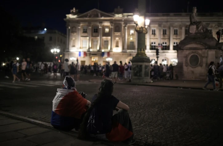 Des supporters attendent devant l'hôtel Le Crillon sur la place de la Concorde à Paris, le 16 juillet 2018