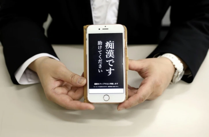 Un responsable de la police tient un téléphone contenant l'application "Digi police", à Tokyo, le 13 mai 2019