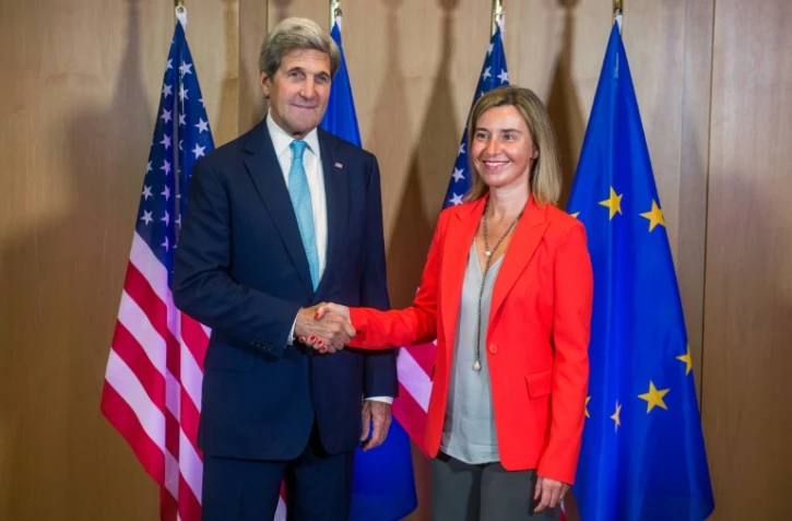 Le secrétaire d'Etat américain John Kerry est accueilli par la chef de la diplomatie européenne Federica Mogherini à Bruxelles, le 18 juillet 2016