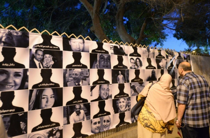 Des Egyptiens regardent le 26 mai 2016, au Caire, les portraits des 66 victimes du vol MS804 d'Egyptair qui s'est abîmé le 19 mai, entre la Crète et la côte nord de l'Égypte