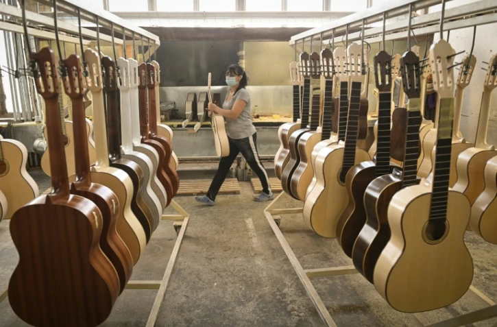Des guitares prĂŞtes Ă ĂŞtre vernies dans un atelier de lutherie de Reghin, en Roumanie, le 22 janvier 2021