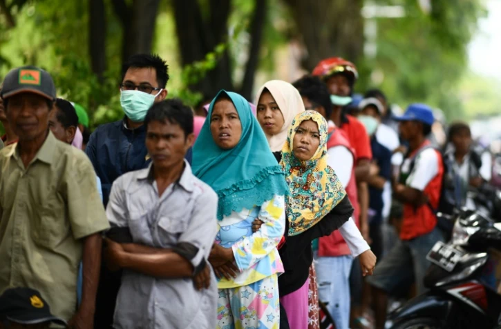 Des habitants de la zone touchée par le séisme et le tsunami font la queue pour recevoir une aide, le 4 octobre 2018 à Palu, en Indonésie