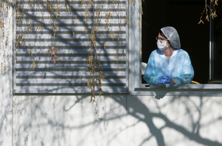 Un membre du personnel soignant se repose quelques minutes à la fenêtre de l'hôpital Emile Muller à Mulhouse, le 24 mars 2020 