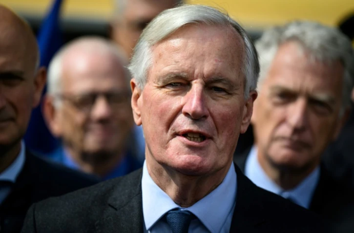 Le Premier ministre Michel Barnier (c) s'adresse aux médias après avoir visité l'Institut national de l'énergie solaire (Ines) au Bourget-du-Lac, le 12 septembre 2024 en Savoie