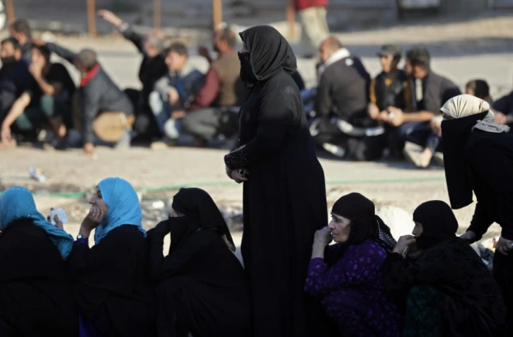 Des Irakiens en file indienne attendent une distribution de nourriture, dans un quartier du centre de Mossoul, le 29 novembre 2016