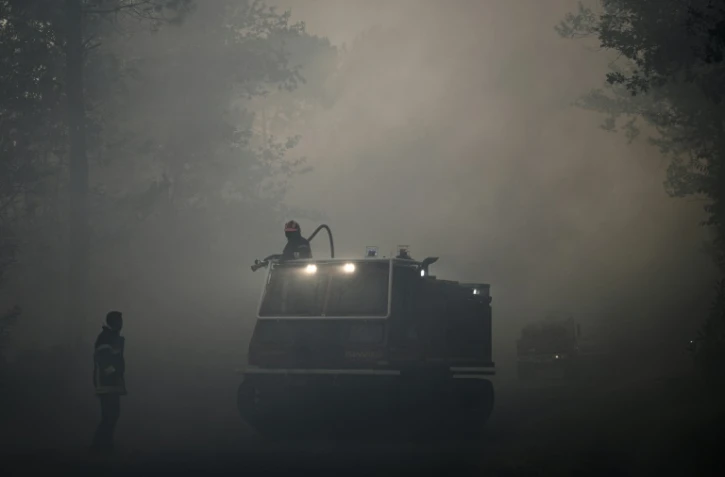 Des pompiers luttent contre un feu de forêt près de Le Tuzan, le 27 juillet 2020 en Gironde
