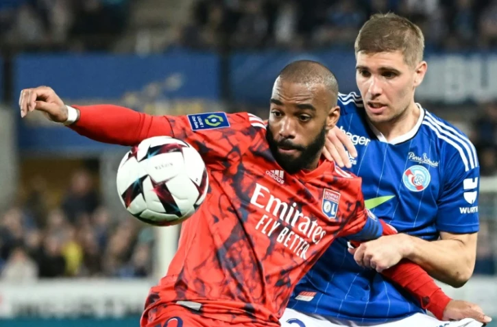 L'attaquant lyonnais Alexandre Lacazette (g) devance le défenseur strasbourgeois Maxime Le Marchand, le 28 avril 2023 à Strasbourg