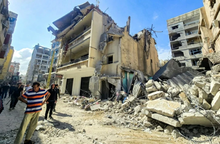 Des habitants devant les décombres de bâtiments endommagés et effondrés après des frappes israéliennes nocturnes sur la ville de Tyr, dans le sud du Liban, le 16 mai 2026