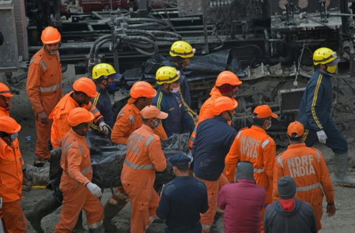Des secouristes transportent le corps d'une victime retrouvée dans un tunnel à Tapovan, le 14 février 2021 en Inde