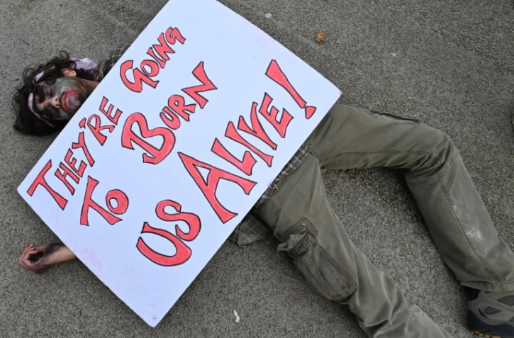 Des manifestants s'allongent sur la voie publique en simulant la mort, signe de protestation contre la COP26, à Glasgow le 7 novembre 2021